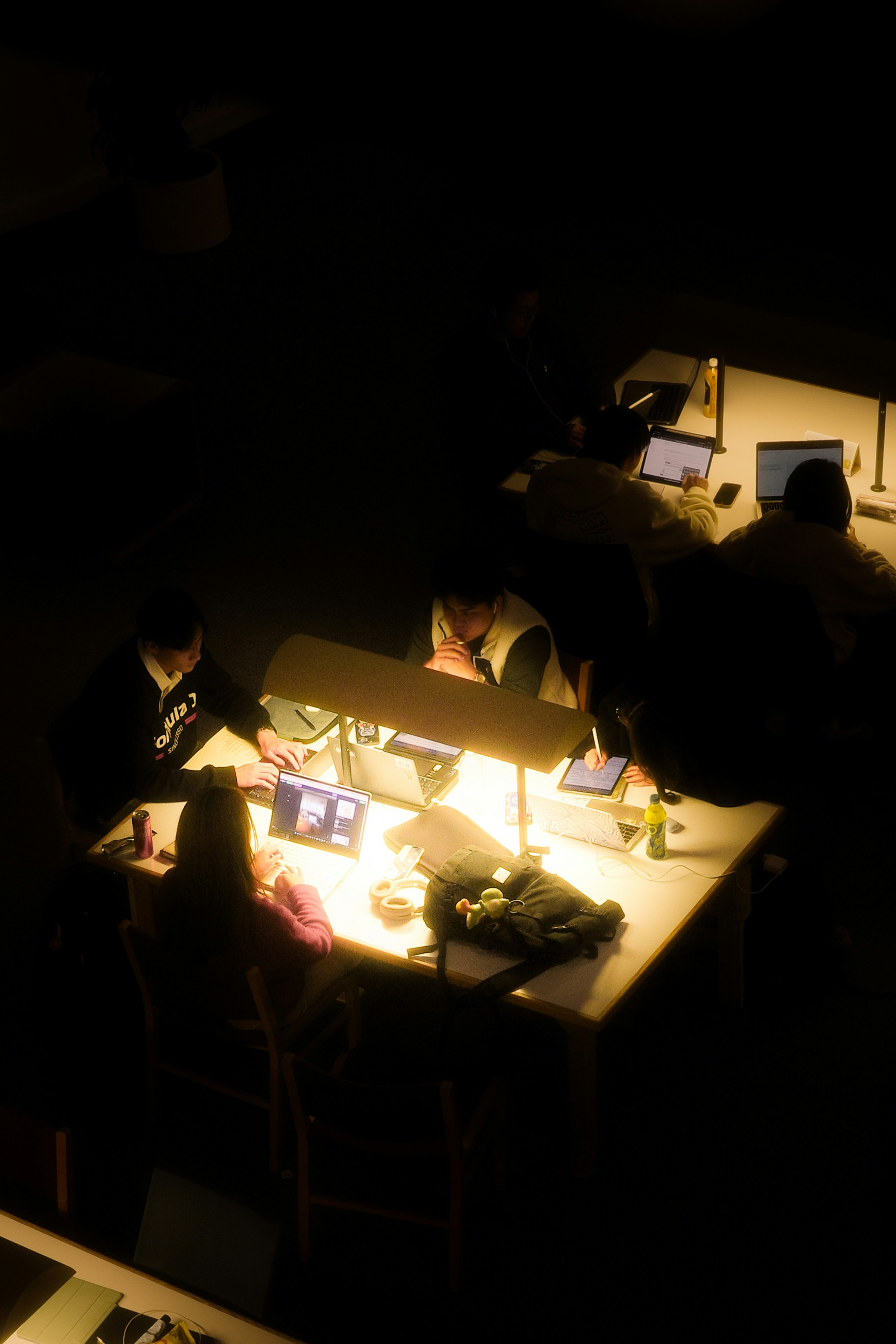 People working together around illuminated library tables